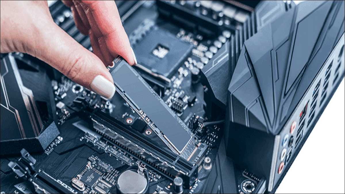 Hands carefully reseating an M.2 SSD inside a Dell laptop to fix a no bootable device error